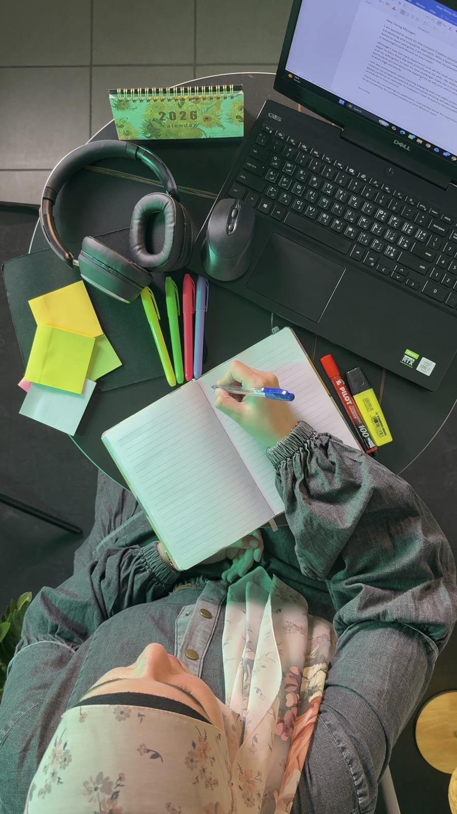 Preparing lessons: notebook, pens and laptop on the teacher's desk
