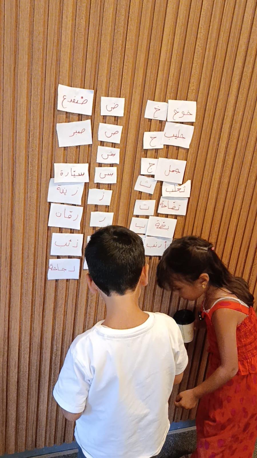 Two students reading word cards pinned to the wall